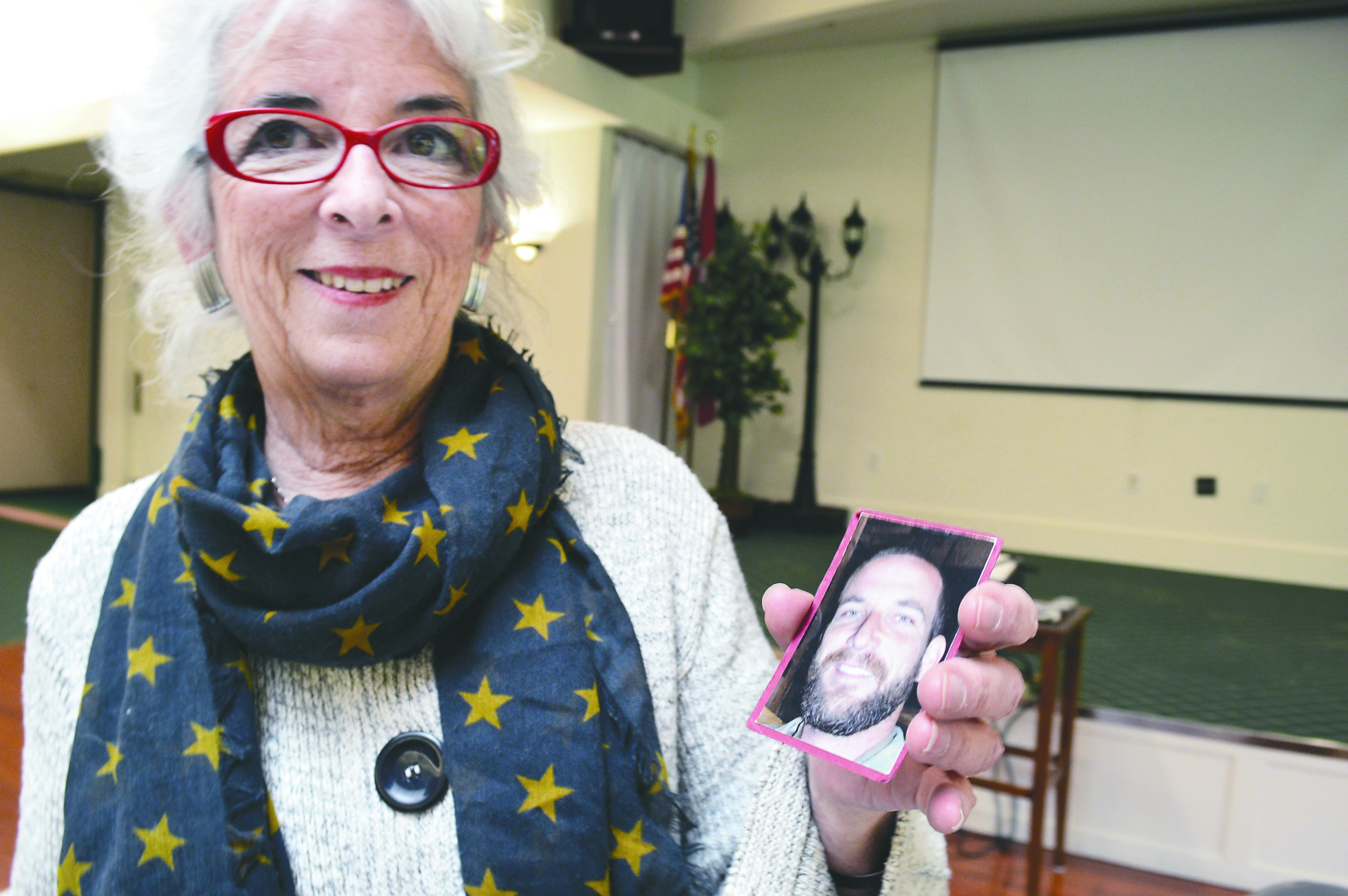 Betsy Reed Schultz holds the picture she carries in her wallet of her son