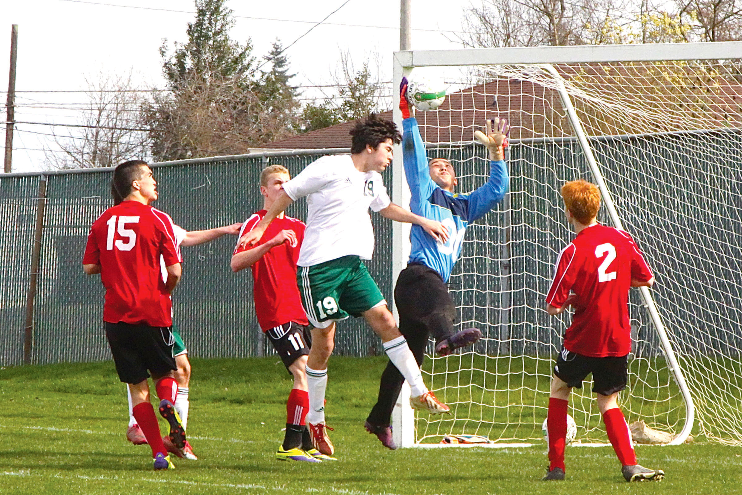 Port Townsend goalkeeper Forrest Piatt grabs the ball after a header by Port Angeles' Jesse Salgado (19). Also in on the play for Port Townsend are Mark Street (15)