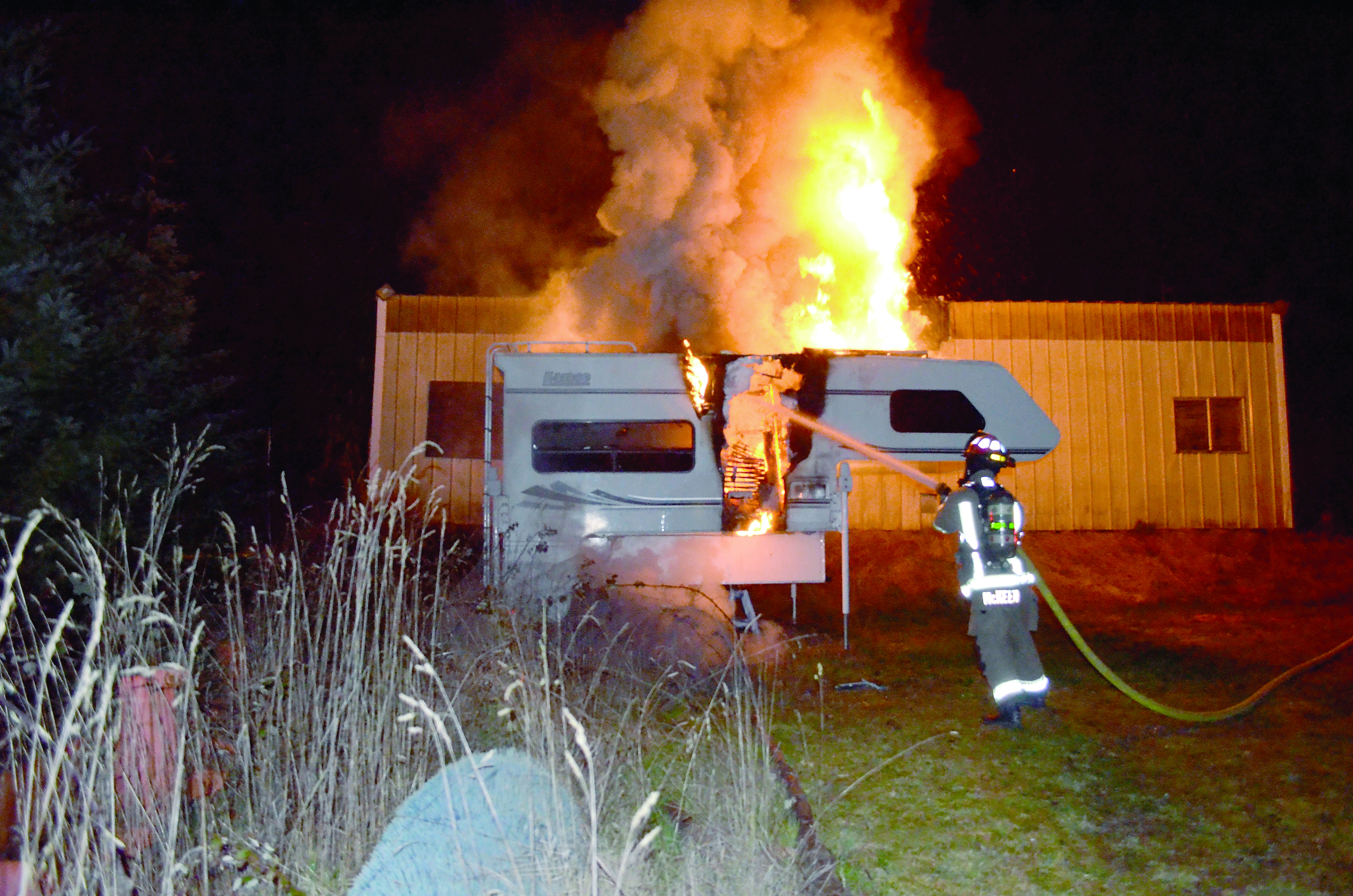 Lt. Joel McKeen extinguishes a burning truck camper on John Jacobs Road in Port Angeles. Clallam County Fire District No. 3