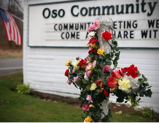 A cross at the Oso Community Chapel is decorated with flowers in dedication to mudslide victims. The Associated Press