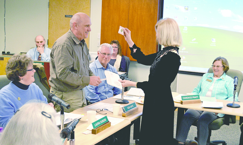 Sequim Mayor Ken Hays and Port Angeles Mayor Cherie Kidd swap commemorative pins at Monday night's Sequim City Council meeting. Seated around the mayors are