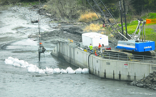 Crews with Macnak Construction dredge debris as part of replacing fish screens on the instakes to the Elwha Water Treatment Plant on Wednesday west of Port Angeles. Keith Thorpe/Peninsula Daily News