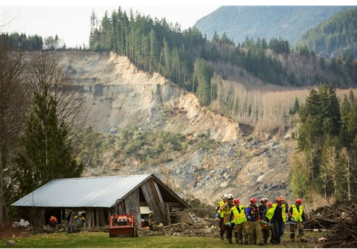 Rescue workers remove the body of a victim of the Oso mudslide from a wrecked home. The Associated Press