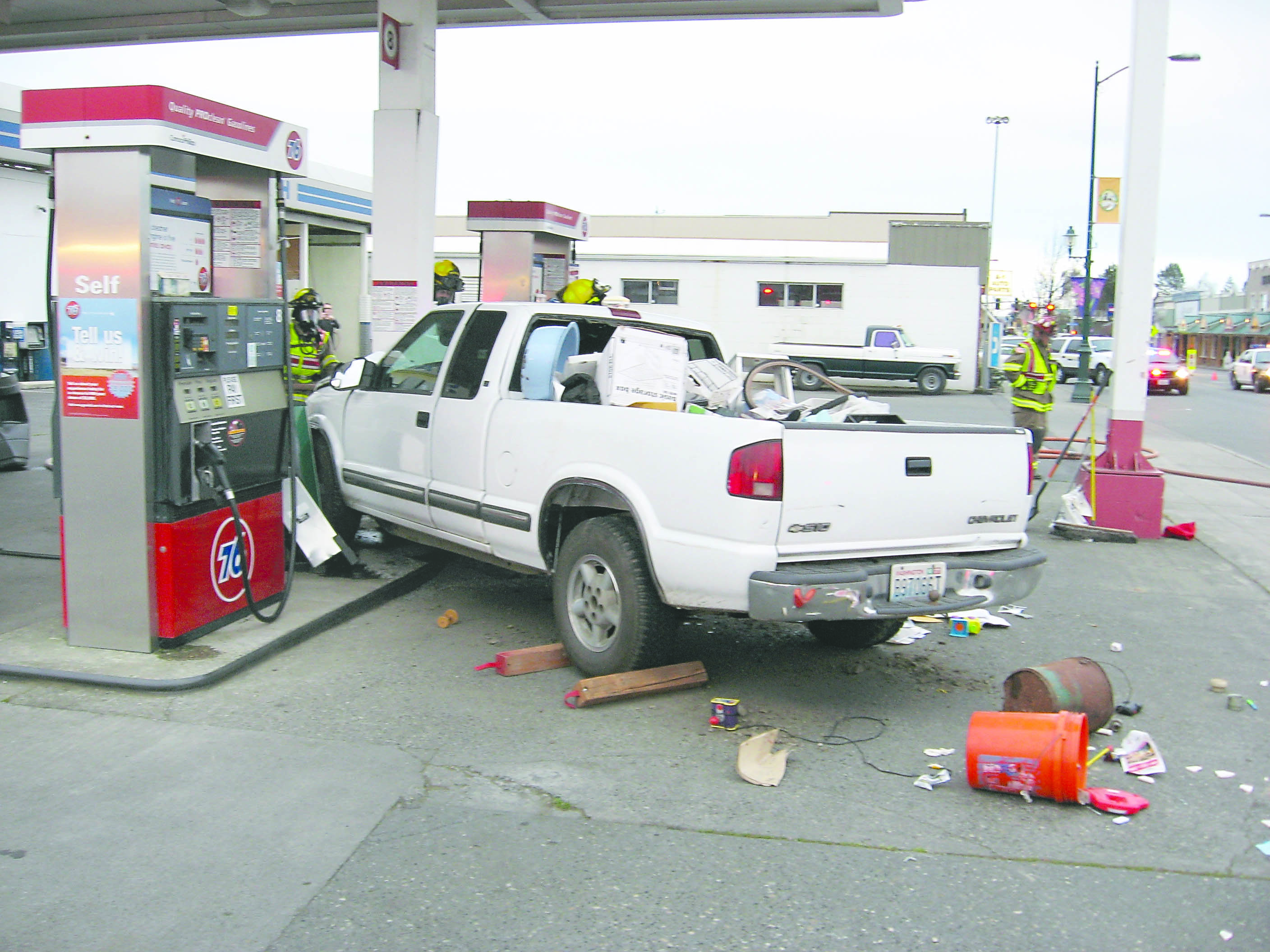 Debris litters the pavement after the pickup truck struck a post at Kettel's 76 Station in Sequim.  -- Clallam County Sheriff's Office photo