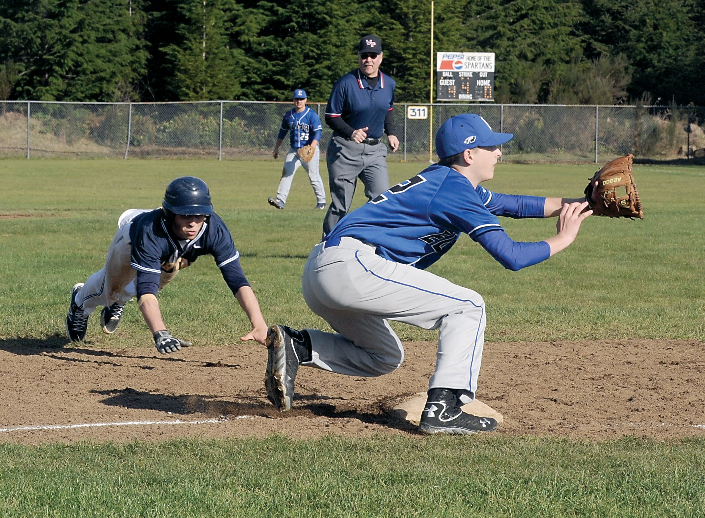 Forks runner Javier Contreras attempts to steal third base in a 12-0 loss to Elma at Fred Orr Memorial Fields in Beaver. Lonnie Archibald/For Peninsula Daily News