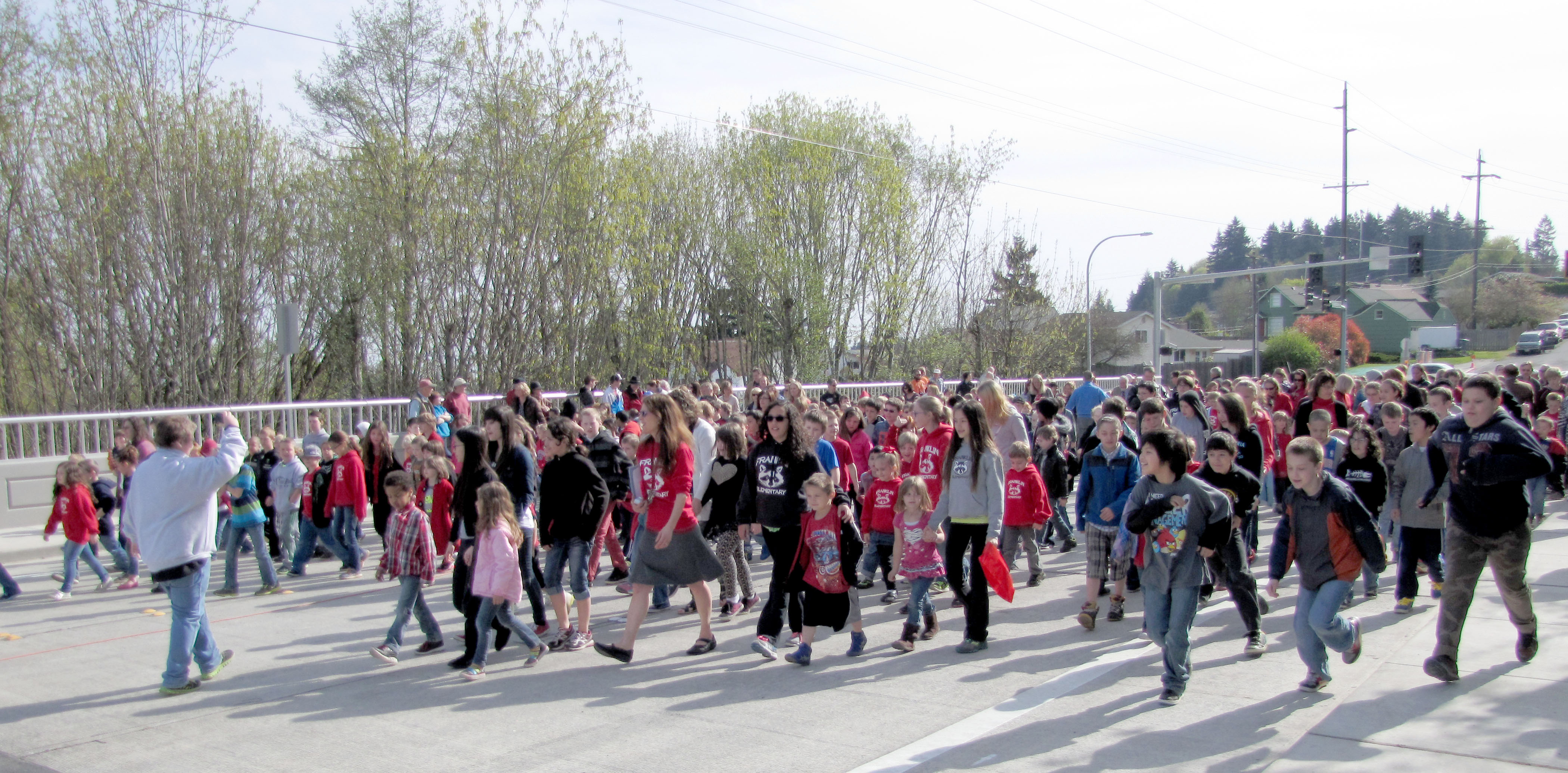 Hundreds of schoolchildren are among the first to walk across the new three-lane Lauridsen Boulevard bridge over Peabody Creek following ribbon-cutting ceremonies Monday.  — Photo by Arwyn Rice/Peninsula Daily News