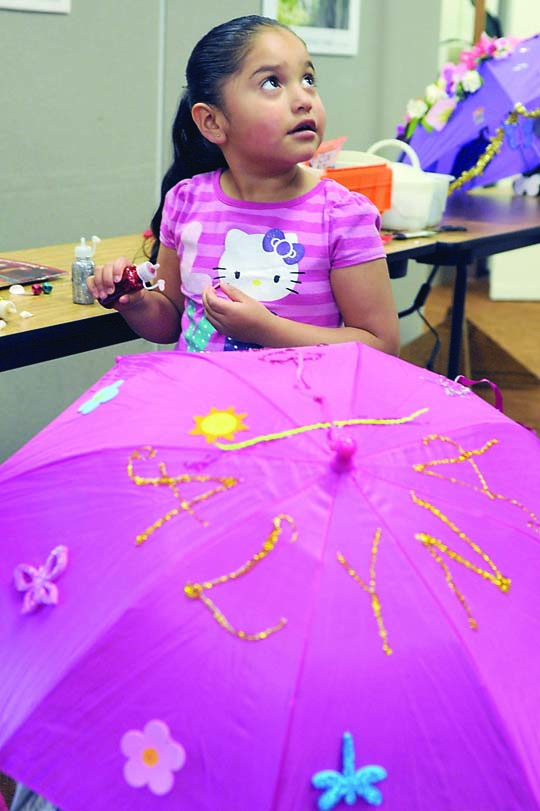 Alyna Centeno of Forks puts the final touches on her umbrella for 2013's RainFest parade. Lonnie Archibald/for Peninsula Daily News