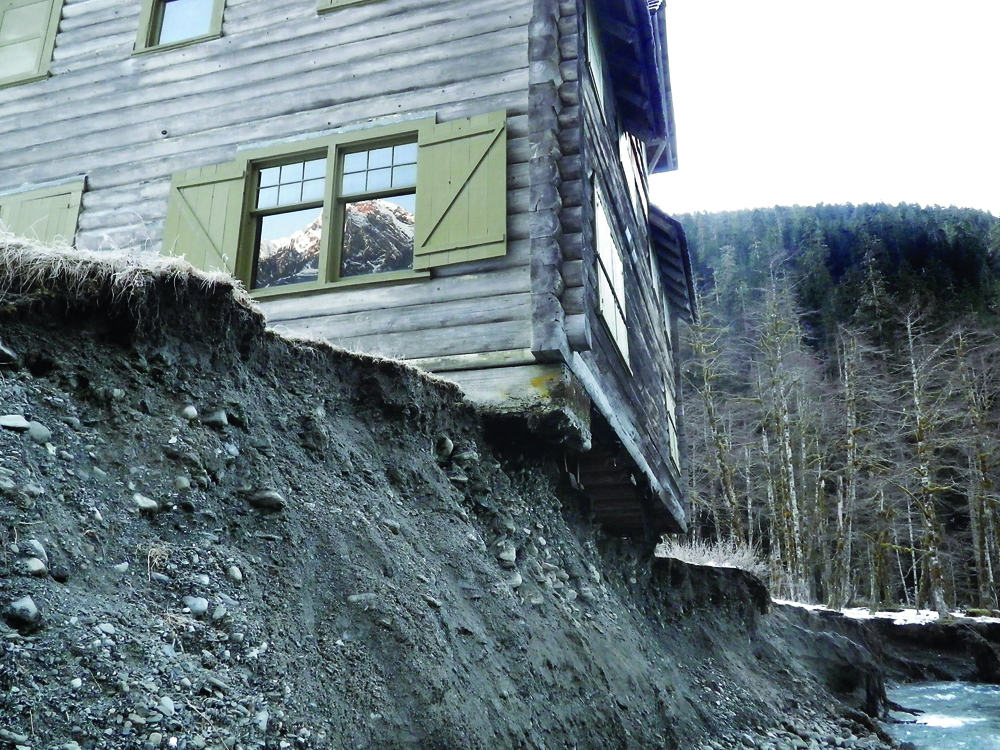 The edge of the historical Enchanted Valley Chalet hangs precariously over the East Fork of the Quinault River