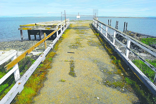 An abandoned dock once used for an oyster processing operation sits closed off at Dungeness Landing County Park near Dungeness. For a view of the long pier and the town of Dungeness in its heyday