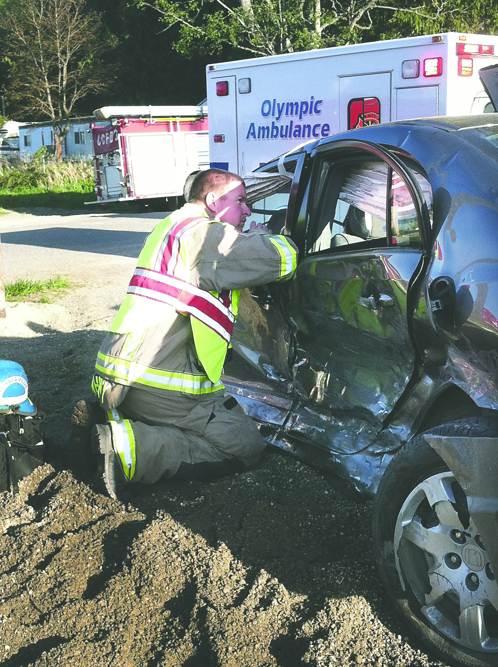 Clallam County Fire District No. 3 paramedic Ron Whitney evaluates one of two drivers involved in a collision on U.S. Highway 101 at Kitchen-Dick Road on Tuesday evening. Patrick Young/Clallam County Fire District No. 3