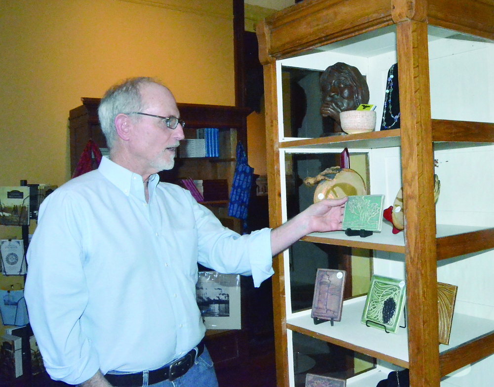 Jefferson County Historical Society Executive Director Bill Tennent straightens out a display in the newly configured museum gift shop. Charlie Bermant/Peninsula Daily News