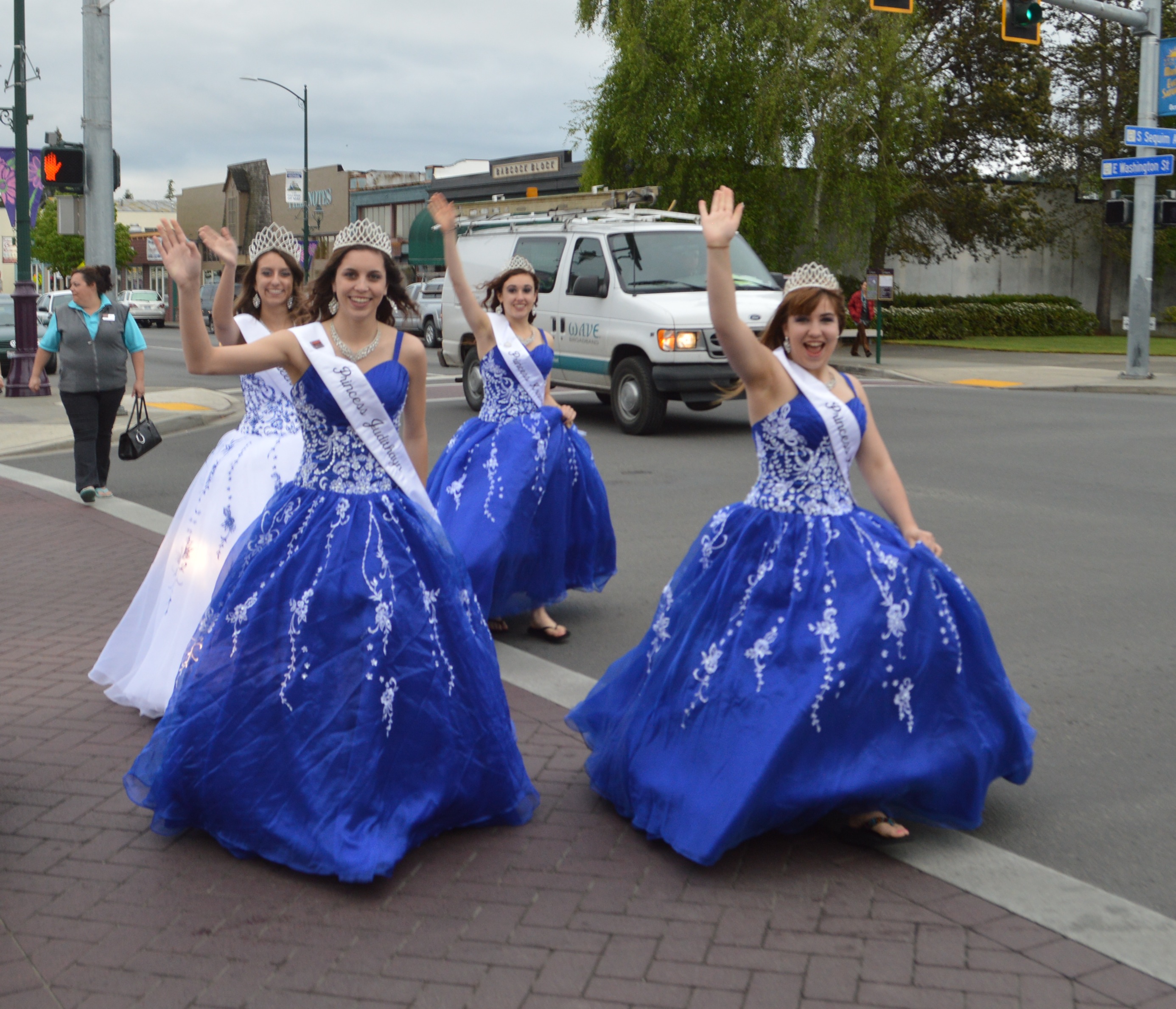 Royalty for Sequim's 119th Irrigation Festival give a welcoming wave as they cross Sequim Avenue on Friday evening. From left