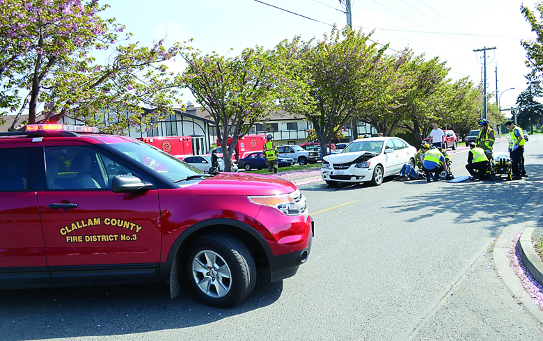 Paramedics from Clallam County Fire District No. 3 and Olympic Ambulance treat an elderly male driver of a vehicle involved in a collision Wednesday. Patrick Young/Clallam County Fire District No. 3