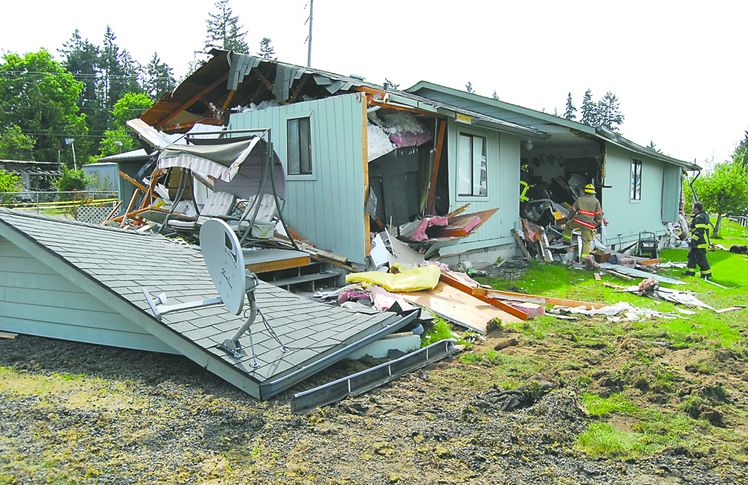 Firefighters examine a house at 3425 Ryan Drive in Gales Addition east of Port Angeles after Friday's bulldozer rampage. Keith Thorpe/Peninsula Daily News