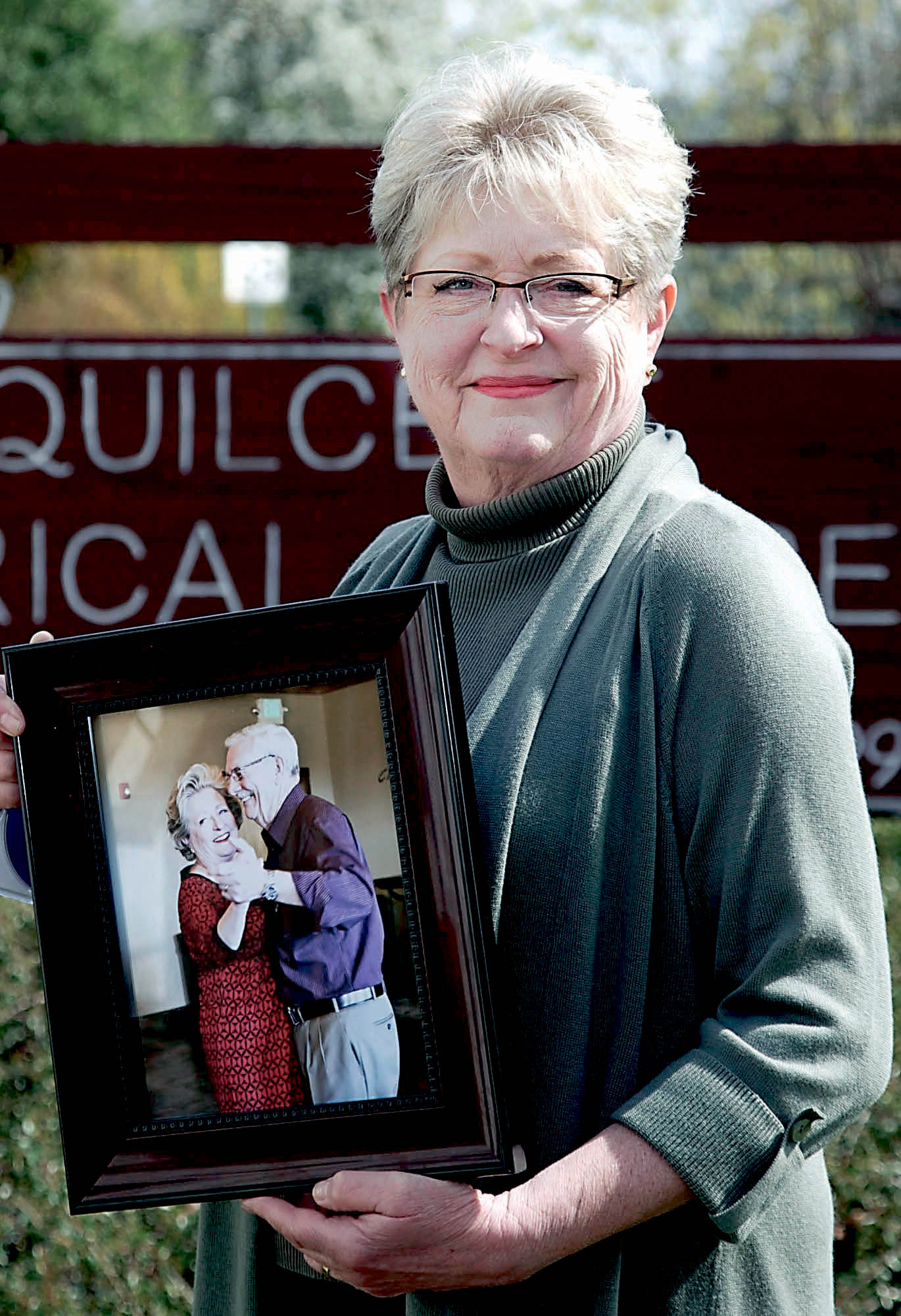 Carol Christiansen holds a photo of her dancing with her husband