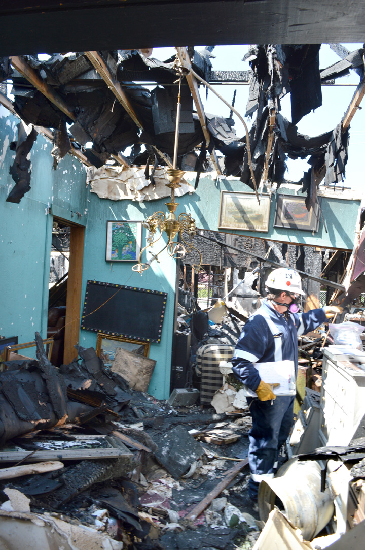 A fire investigator assesses on Tuesday damage done to the Sequim Consignment Co. in the May 19 fire that all but destroyed the building that housed the consignment shop and Baja Cantina Mexican restaurant. Joe Smillie/Peninsula Daily News