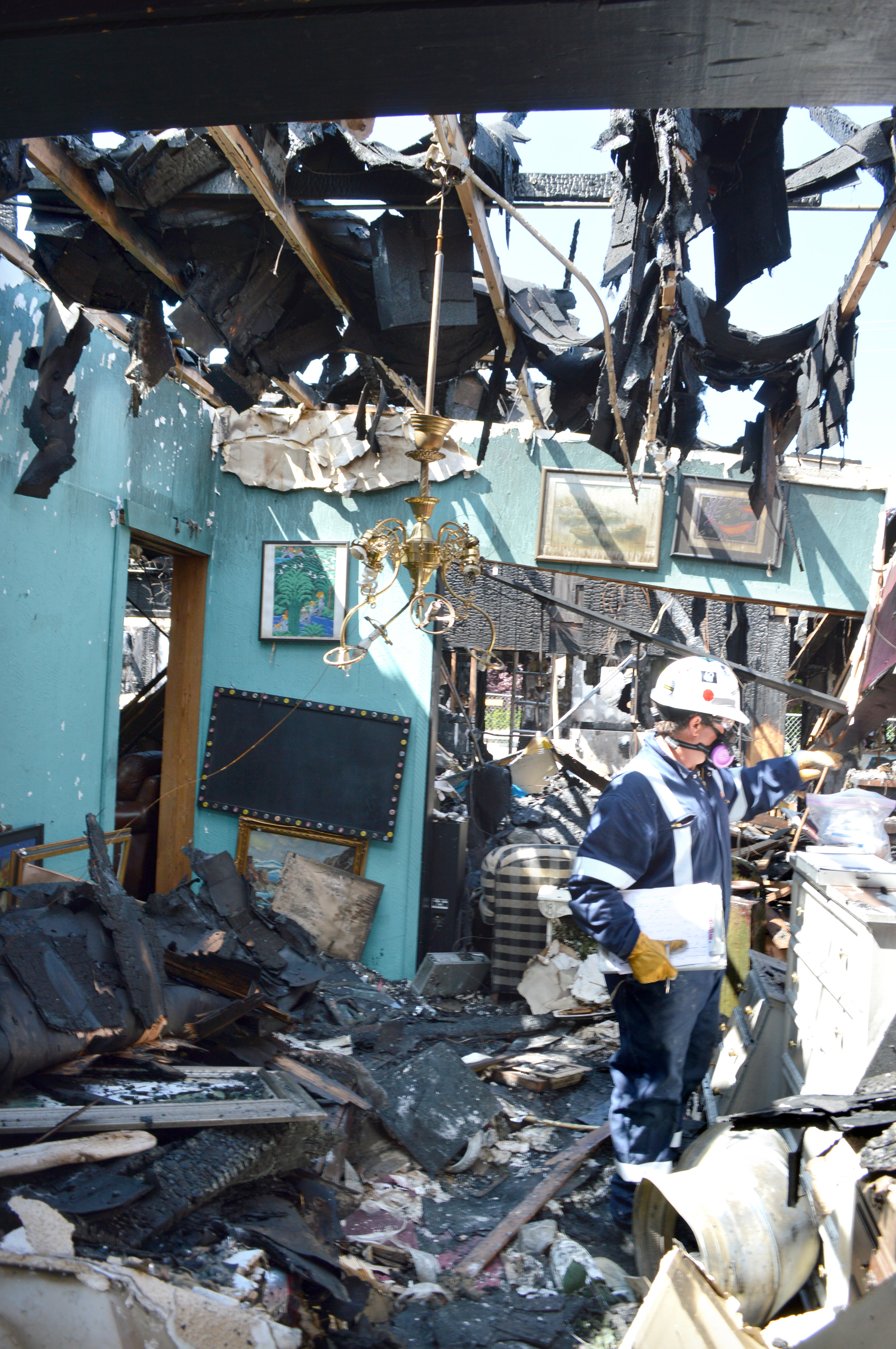 A fire investigator assesses damage done to the Sequim Consignment Co. from the May 19 fire that all but destroyed the building which housed the consignment shop and Baja Cantina Mexican restaurant. Joe Smillie/Peninsula Daily News