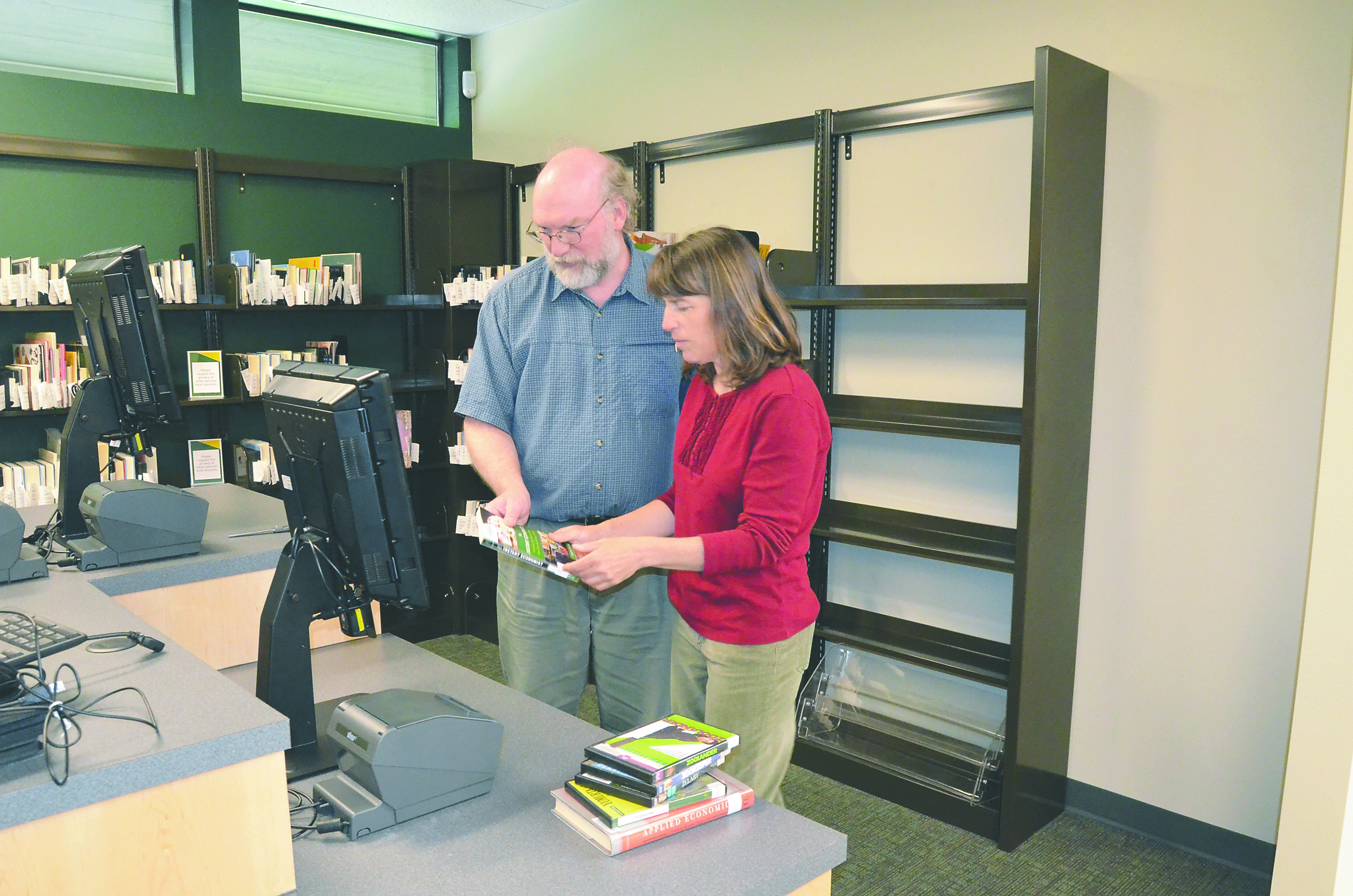 Jefferson County Library employee Jim Nyby demonstrates the new automated checkout machine with wife