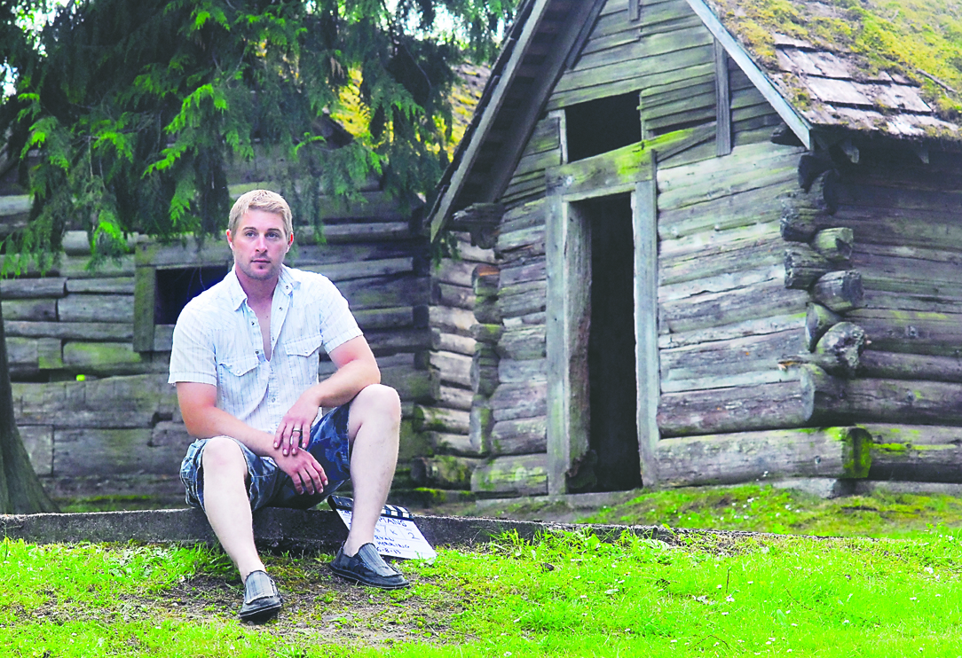 Filmmaker Ryan Herring sits among the cabins at Lincoln Park in Port Angeles on Thursday