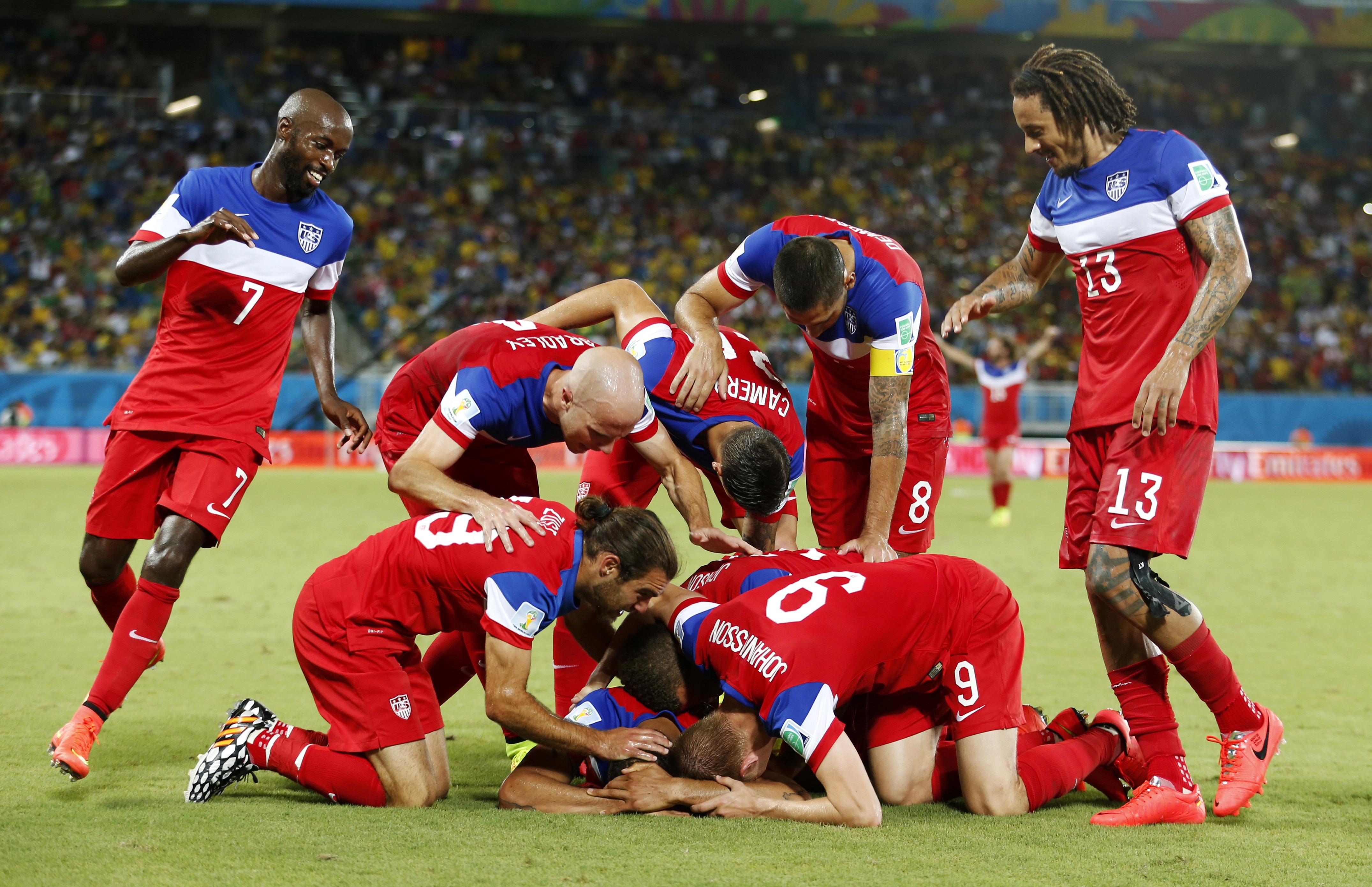 The United States team surrounds John Brooks after he scored his side's second goal to defeat Ghana 2-1 on Monday. The Associated Press