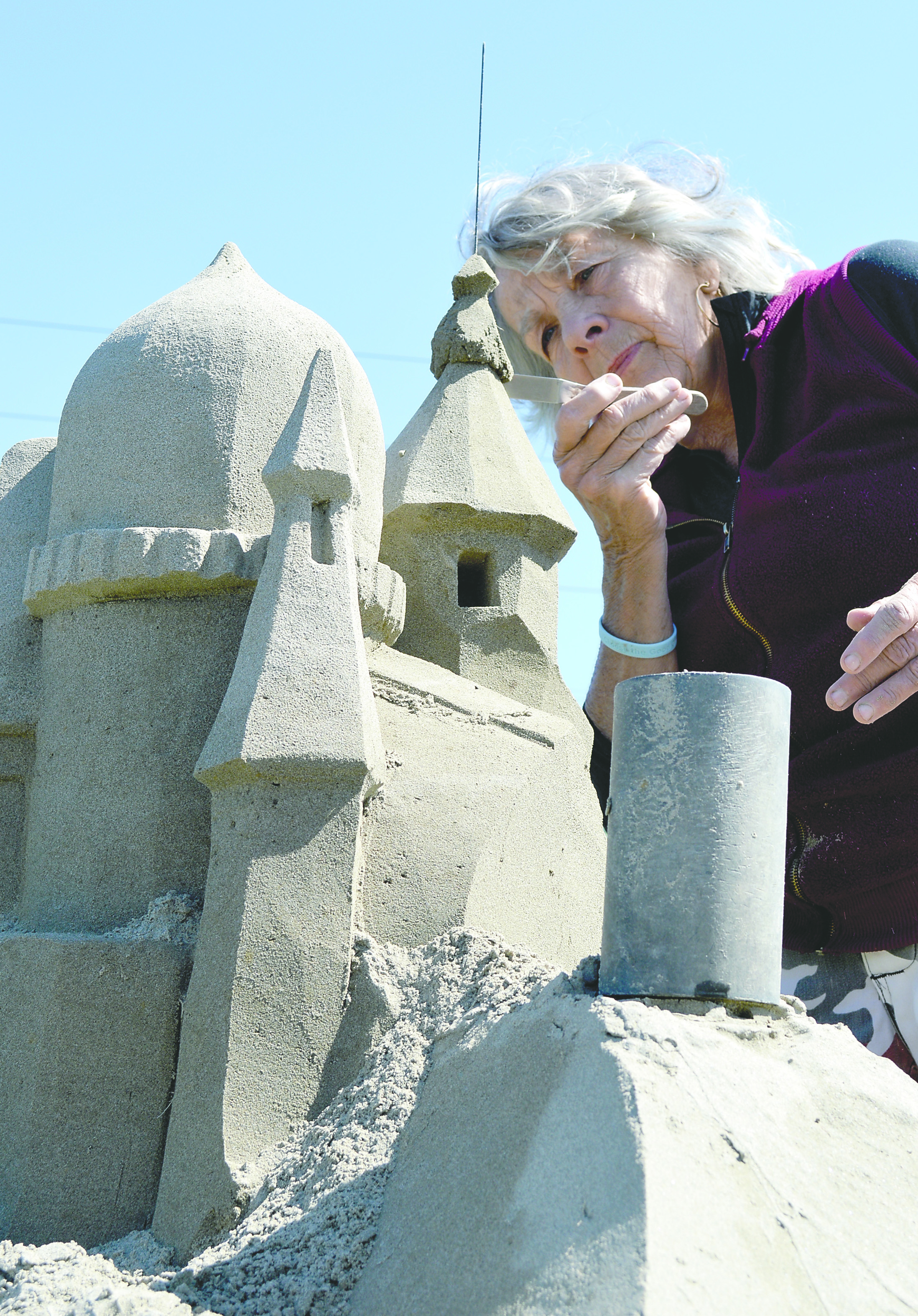 Sequim artist Kali Bradford sculpts the top of a 10-foot sand castle she is building at the city's east end for July's Lavender Weekend. Joe Smillie/Peninsula Daily News