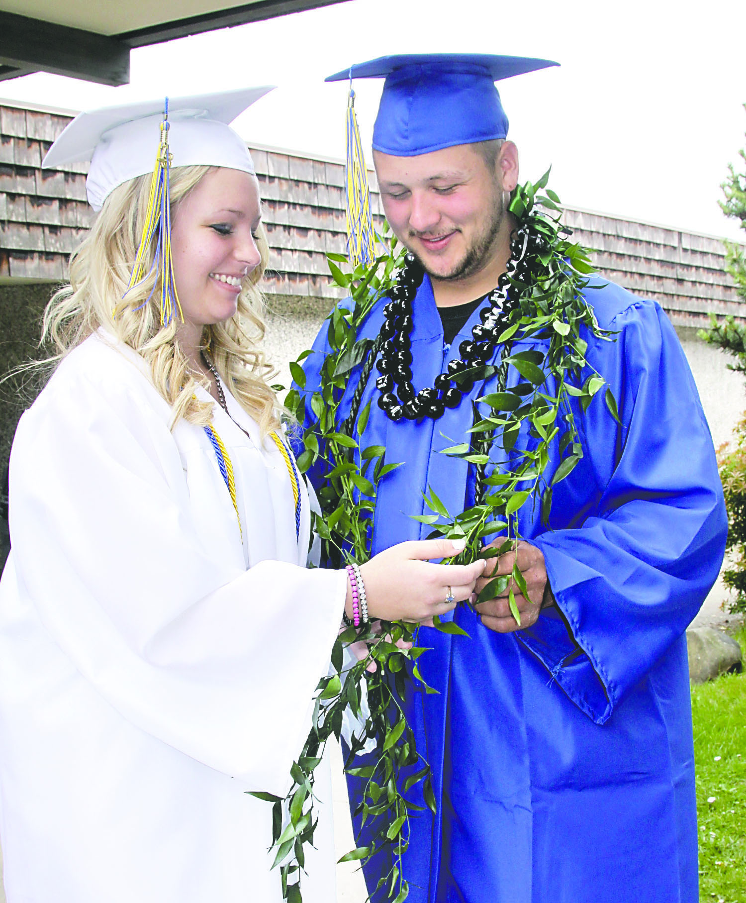 Crescent High School graduate Bonny Hazelett examines the Hawaiian leaves and kukui nut necklace around the neck of Kaialii Story. Relatives in Hawaii sent him traditional Hawaiian graduation adornments. Dave Logan/for Peninsula Daily News