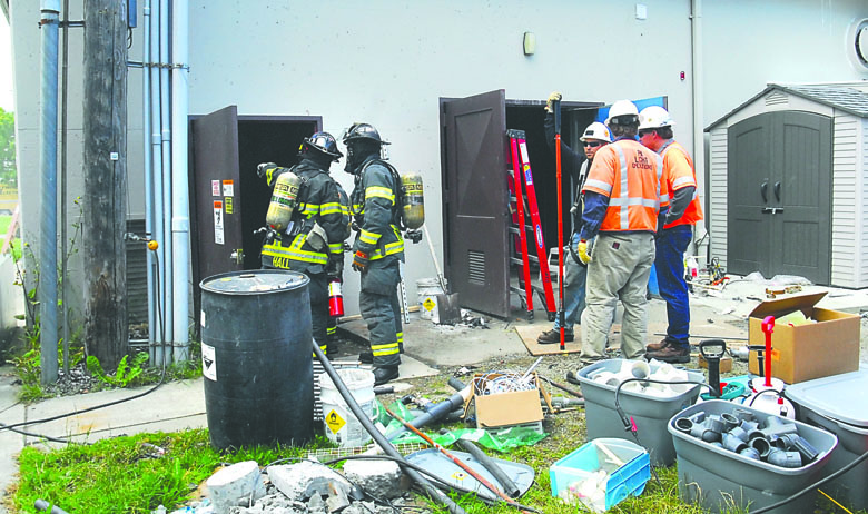 Port Angeles utility workers stand by among scattered construction equipment as Port Angeles firefighters examine a power utility room at William Shore Memorial Pool after an electrical short knocked out power to the pool and nearby City Hall on Friday. Keith Thorpe/Peninsula Daily News