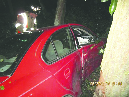 An East Jefferson Fire-Rescue firefighter examines a crumpled 2003 Oldsmobile Alero that was driven off the road into trees on West Sims Way near Mill Road last week. Port Townsend Police Department