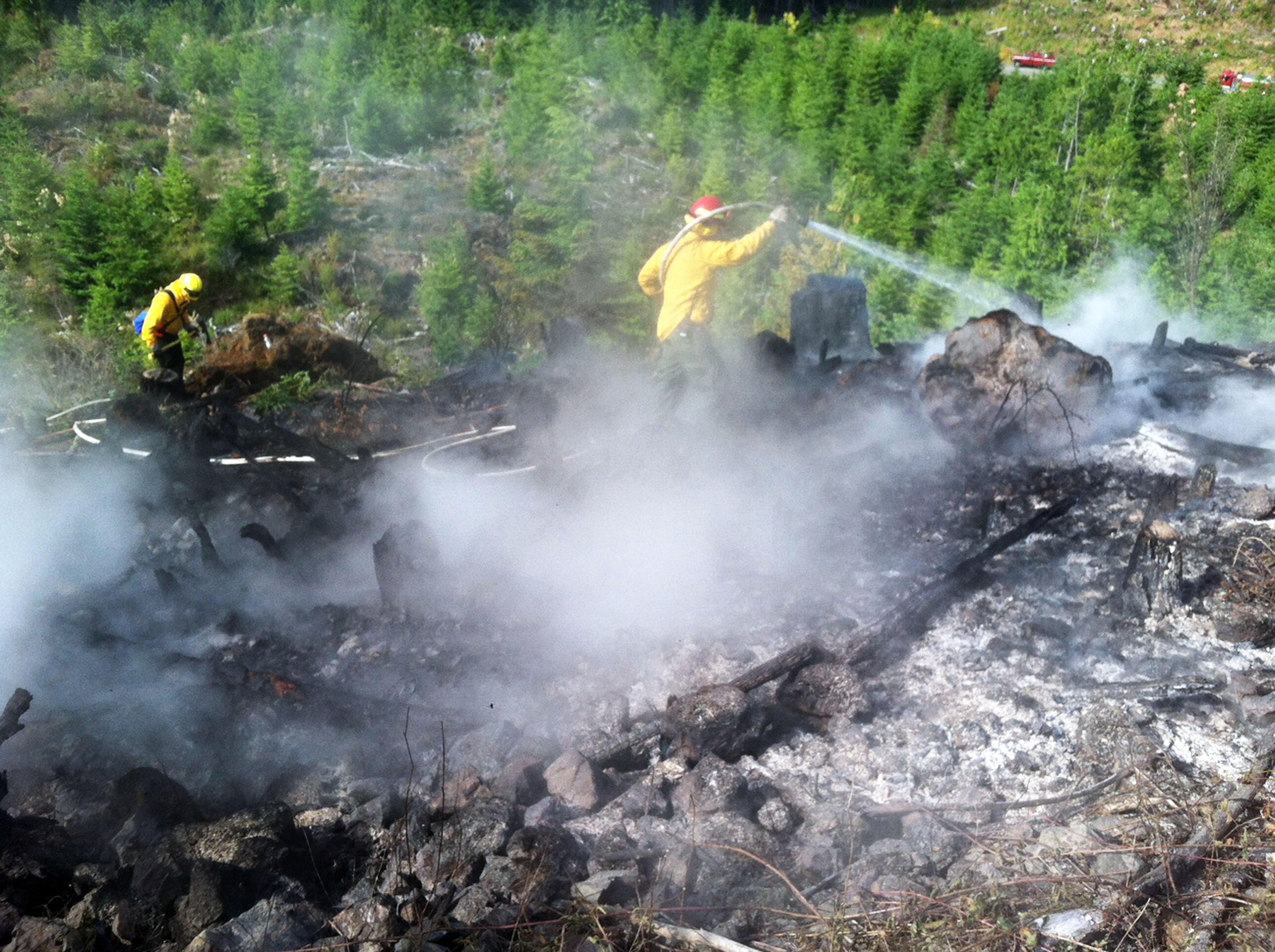 Clallam County Fire District No. 2 firefighters work on a brush fire in logging slash near Lake Sutherland today (Friday). Clallam County Fire District No. 2