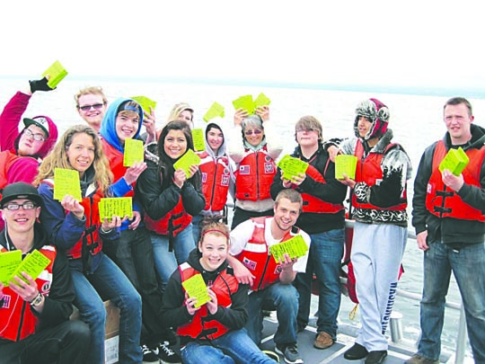 A group of students from Port Angeles' Lincoln High School get ready to release drift cards into the Strait of Juan de Fuca from a Coast Guard vessel earlier this year. Deb Volturno