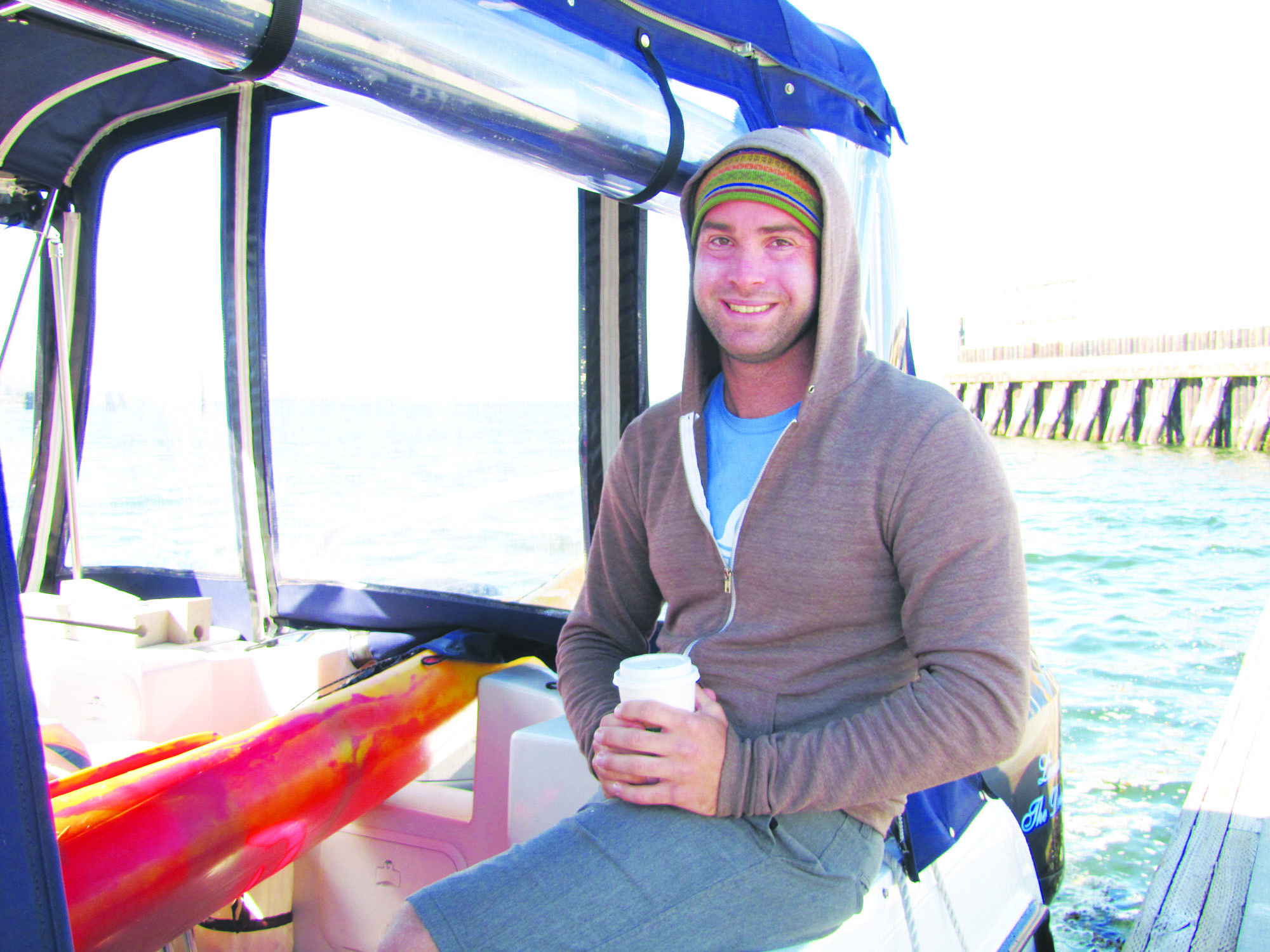 Andrew Malinak warms up aboard the Livin the Dream catamaran at Port Angeles' Boat Haven after cutting short his attempt to swim across the Strait of Juan de Fuca from Vancouver Island. Arwyn Rice/Peninsula Daily News