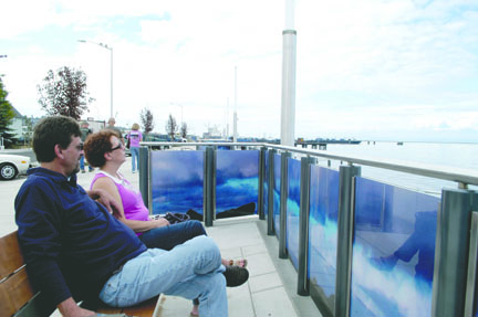 Rick Glende and Lindsay Huff sit on one of the wood-and-metal benches overlooking the newly opened $3.9 million Port Angeles waterfront esplanade Friday afternoon. Glende and Huff were visiting Port Angeles from Wisconsin for a family reunion. Jeremy Schwartz/Peninsula Daily News