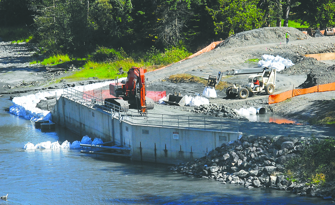 A loader carries sand bags near the Elwha River intakes of the industrial water treatment plant west of Port Angeles late last week. Keith Thorpe/Peninsula Daily News