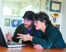 Matt Sircely and Judith-Kate Friedman look at the music video they helped create at the office of Songwriting Works in Port Townsend. Charlie Bermant/Peninsula Daily News