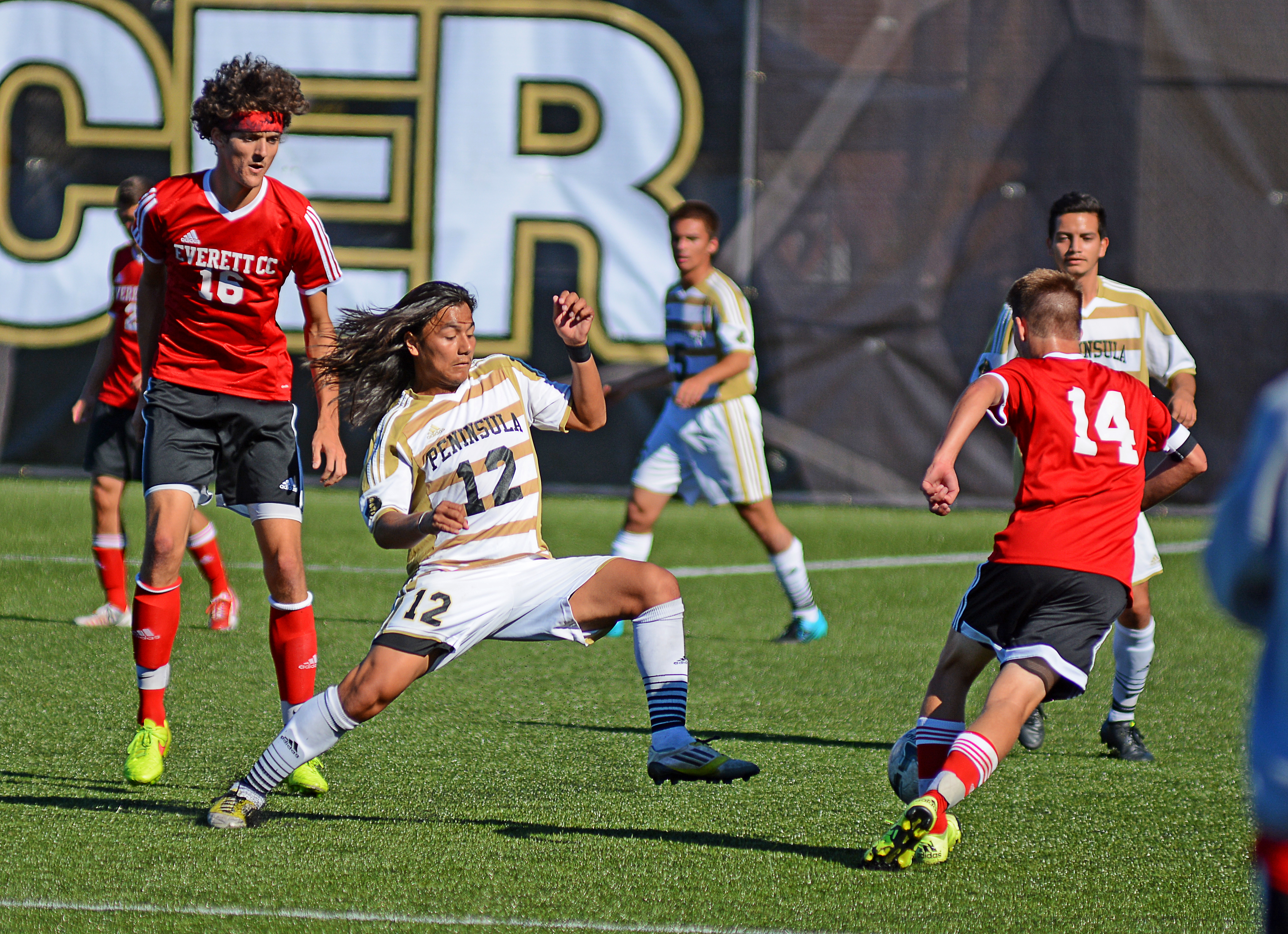 Peninsula's Jonathan Martinez (12) attempts to regain possession from Everett's Nathan Thompson (14)