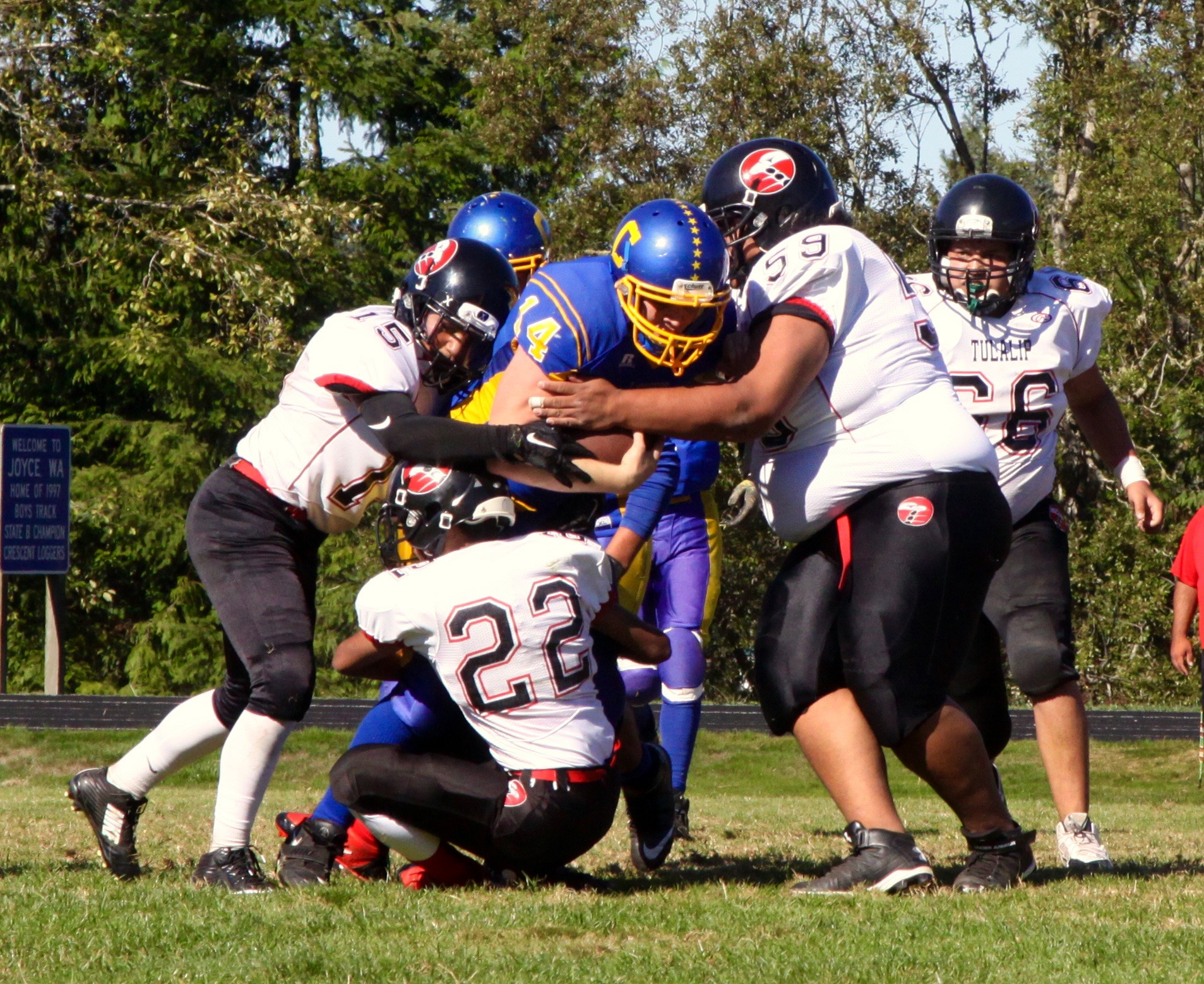 Crescent quarterback Neil Peppard (14) is tackled by Tulilap Heritage's Nashona Whitebear (15)