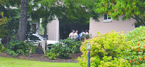 Clallam County sheriff's deputies confer in the garage of Marjorie Root at 247 Taylor Blvd. in SunLand