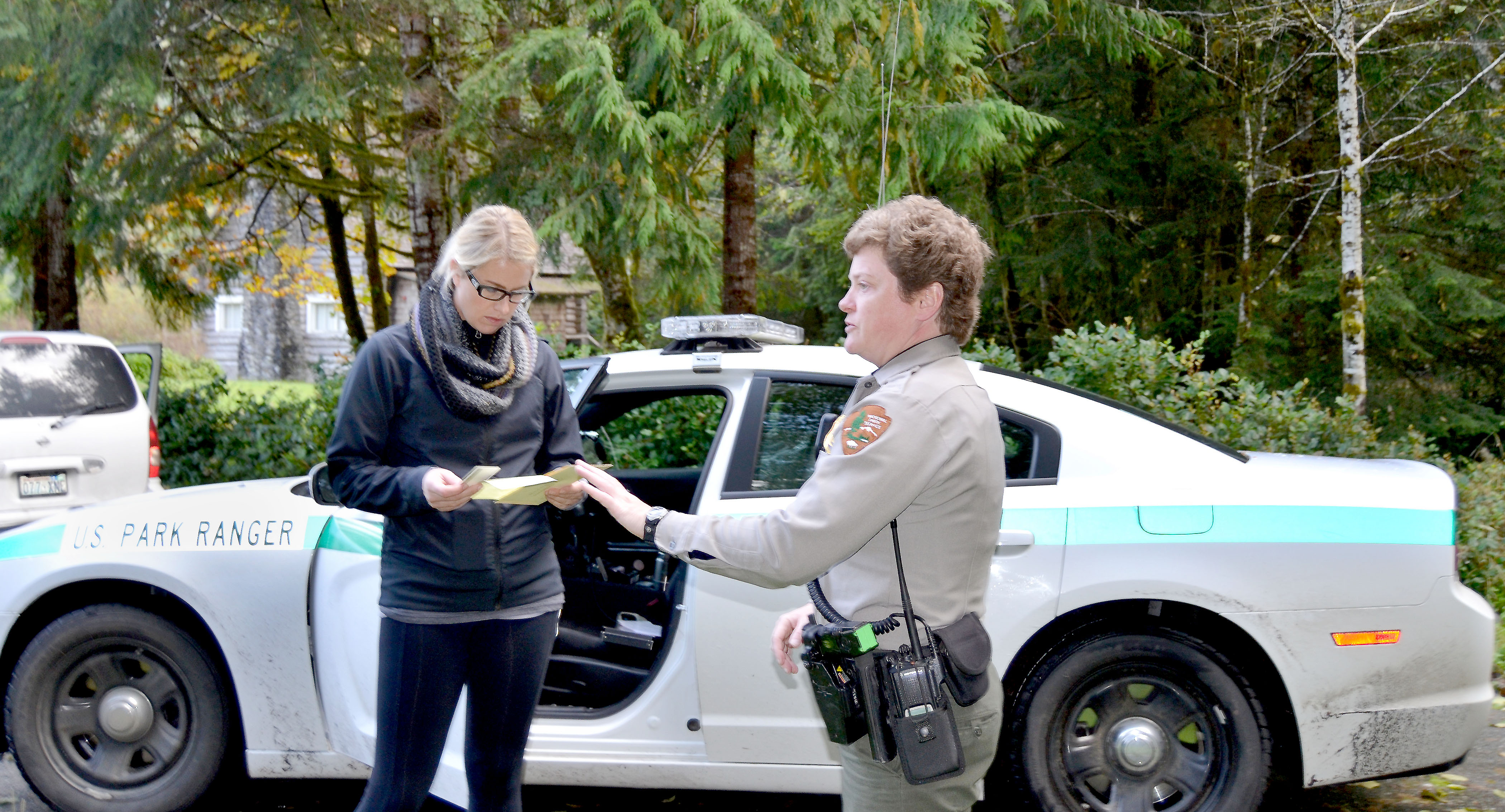 Olympic National Park Ranger Jennifer Jackson hands a ticket for "Violation of Closure (Government Shutdown)" to Leanne Potts of Sequim near Storm King Ranger Station at Lake Crescent over the weekend. The citation carries a $125 fine. Kelly Sanders