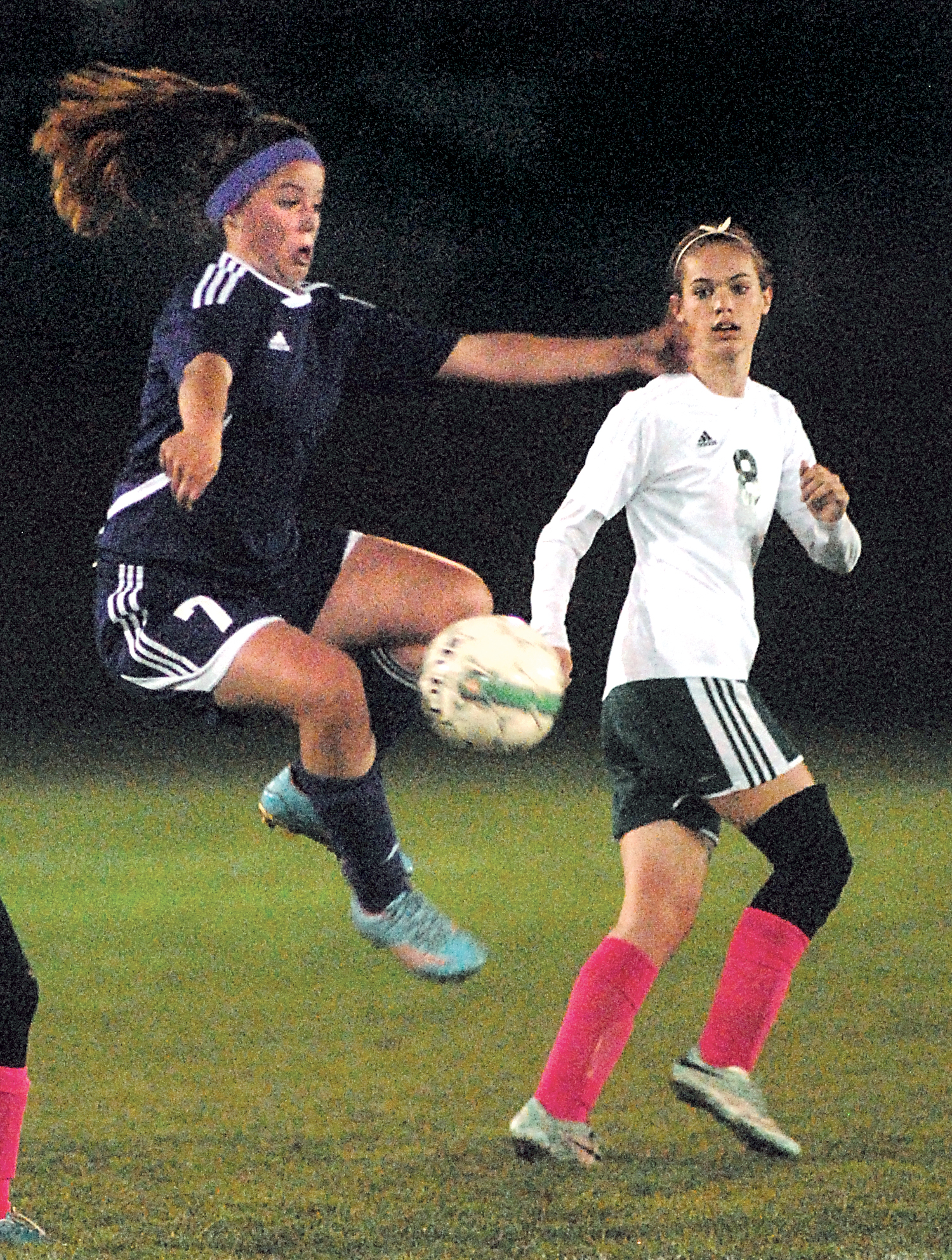 Sequim's Aylee Bennett leaps for a loose ball as Port Angeles' Emma Smith looks on during the first half on Thursday night at Civic Field in Port Angeles. Keith Thorpe/for Peninsula Daily News