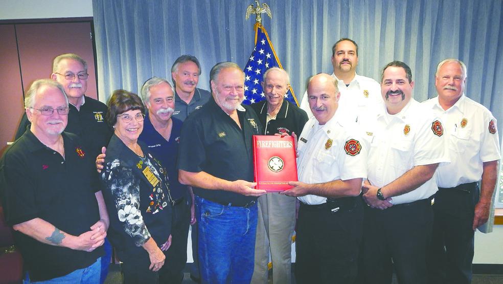 Members of the Olympic Peninsula Chapter of the International Footprint Association present the Clallam County Fire District No. 3 commissioners and chiefs with a copy of Firefighters. From left are Don Taylor