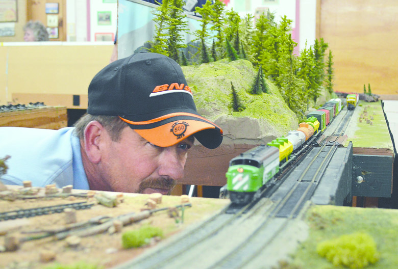 John Kunparak of Sequim watches for a wobble as his model Burlington Northern train heads down the track at the North Olympic Peninsula Railroaders' train show Saturday in the Sequim Prairie Grange Hall. Joe Smillie/Peninsula Daily News