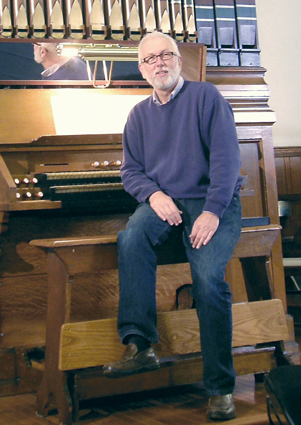 Woody Bernas sits at the console of the 1902 Mudler organ at Trinity United Methodist Church in Port Townsend. He'll debut the church's new replica of an 18th-century organ Thursday night.