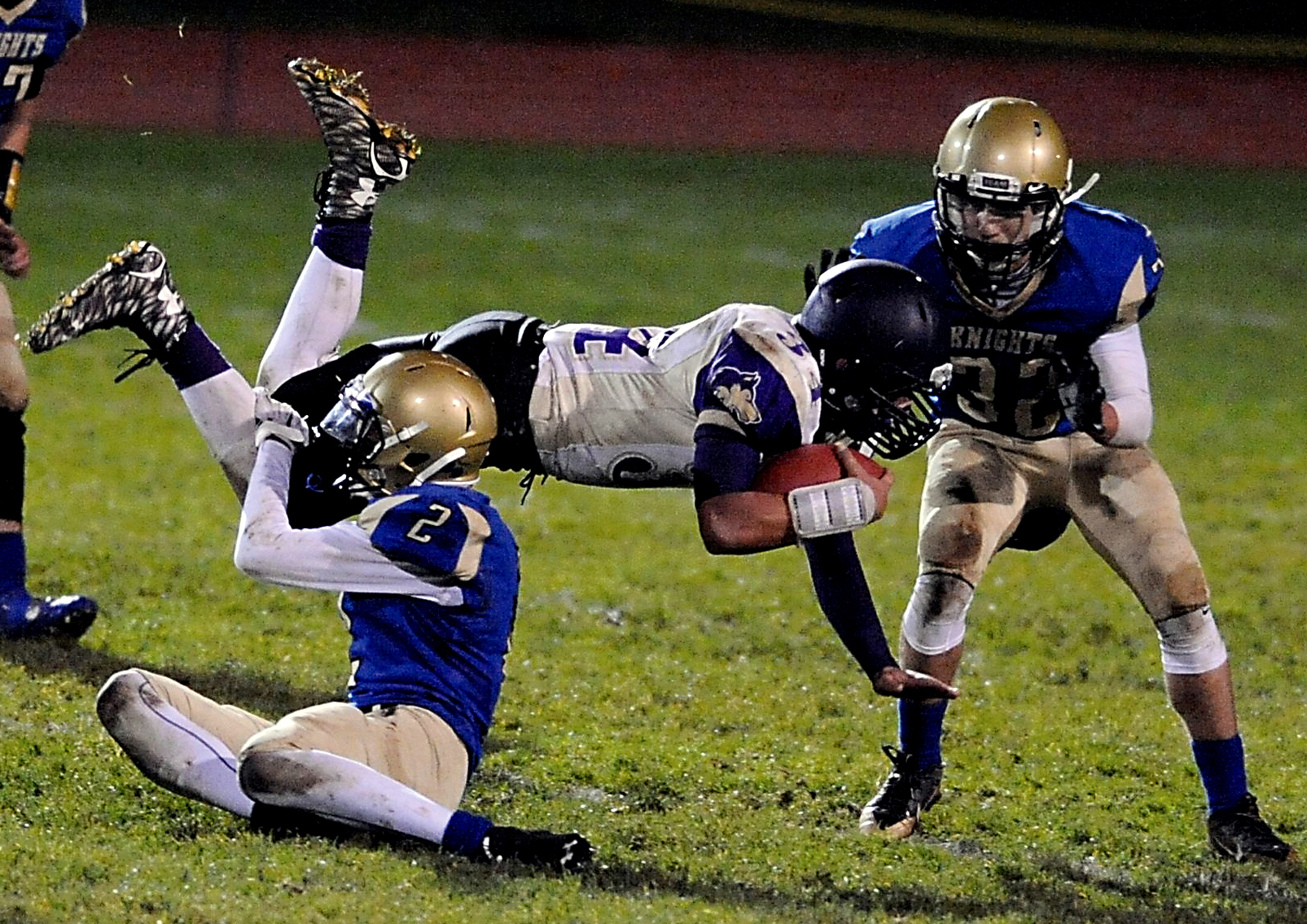 Sequim running back Mark Feeney dives through Bremerton's Teni Vaoifi (2) and Mikhail Papillon (32) for a first down. Feeney ran for 118 yards in the loss. Jeff Halstead/for Peninsula Daily News