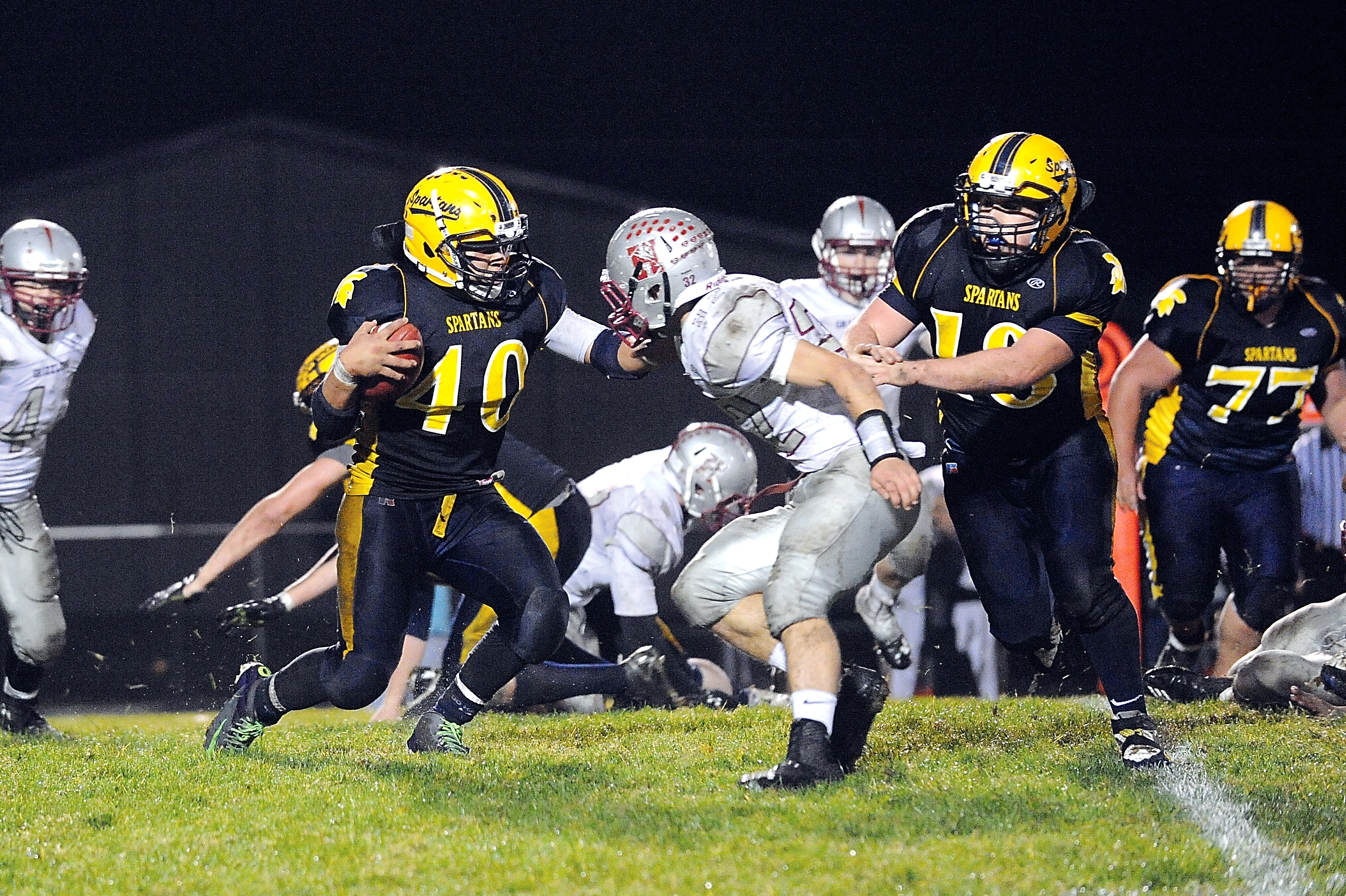 Forks running back Dimitri Sampson (40) looks for running room behind the blocking of Brett Pederson (18) and Tristan Tumaua (77). Lonnie Archibald/for Peninsula Daily News