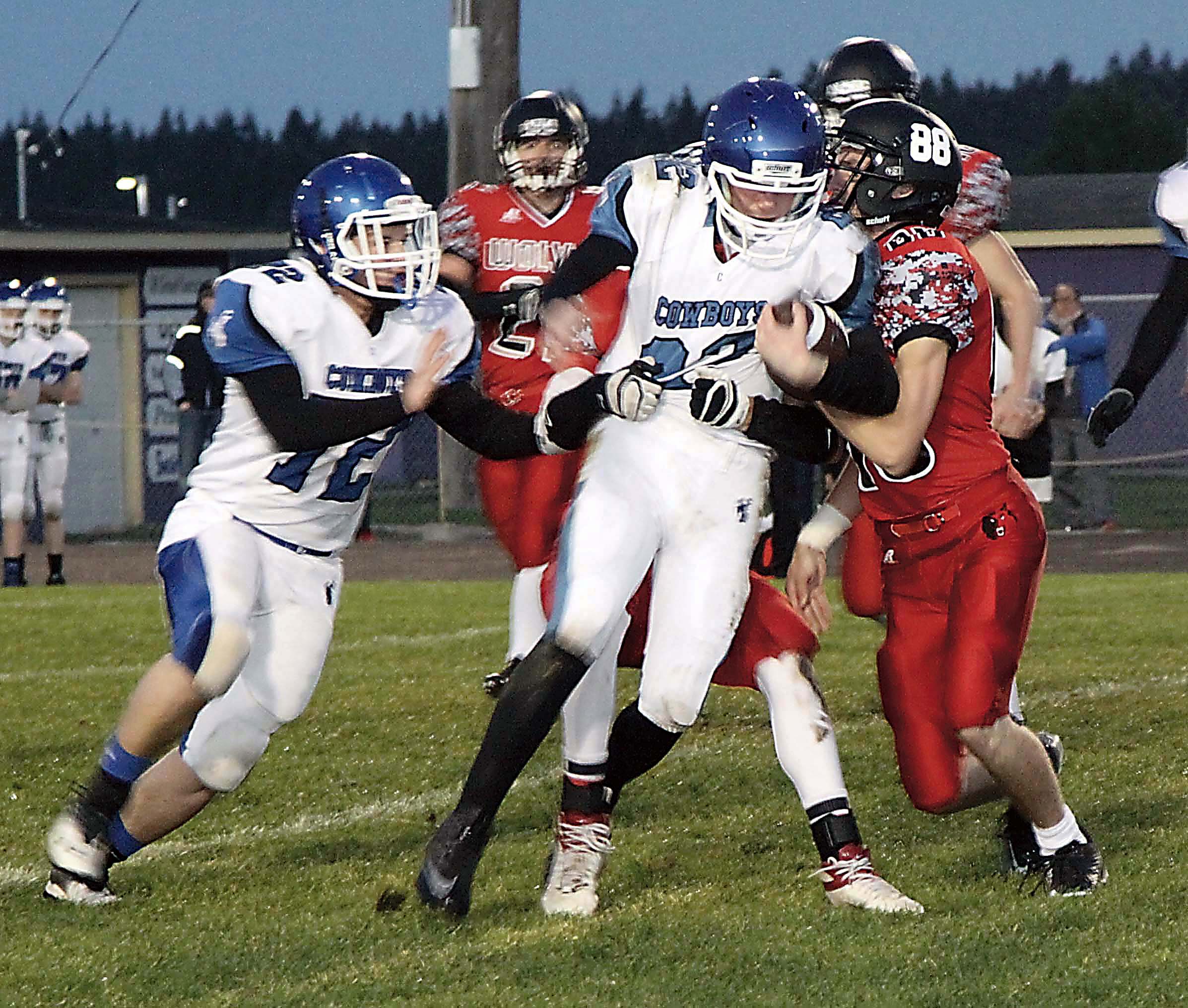 Chimacum's Logan Shaw (with ball) fights for yardage against Coupeville's Ben Ford