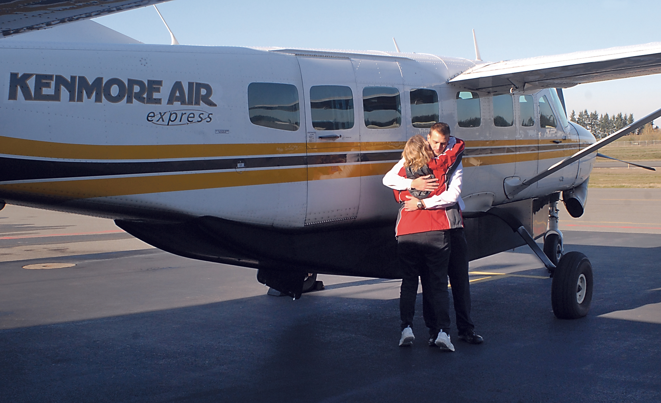 Kenmore Air Express ticket agent Robin McHattie gets a hug from pilot Bill Martin minutes before Flight 5141 departs William R. Fairchild International Airport in Port Angeles for Seattle's Boeing Field for the last time. —Photo by Keith Thorpe/Peninsula Daily News