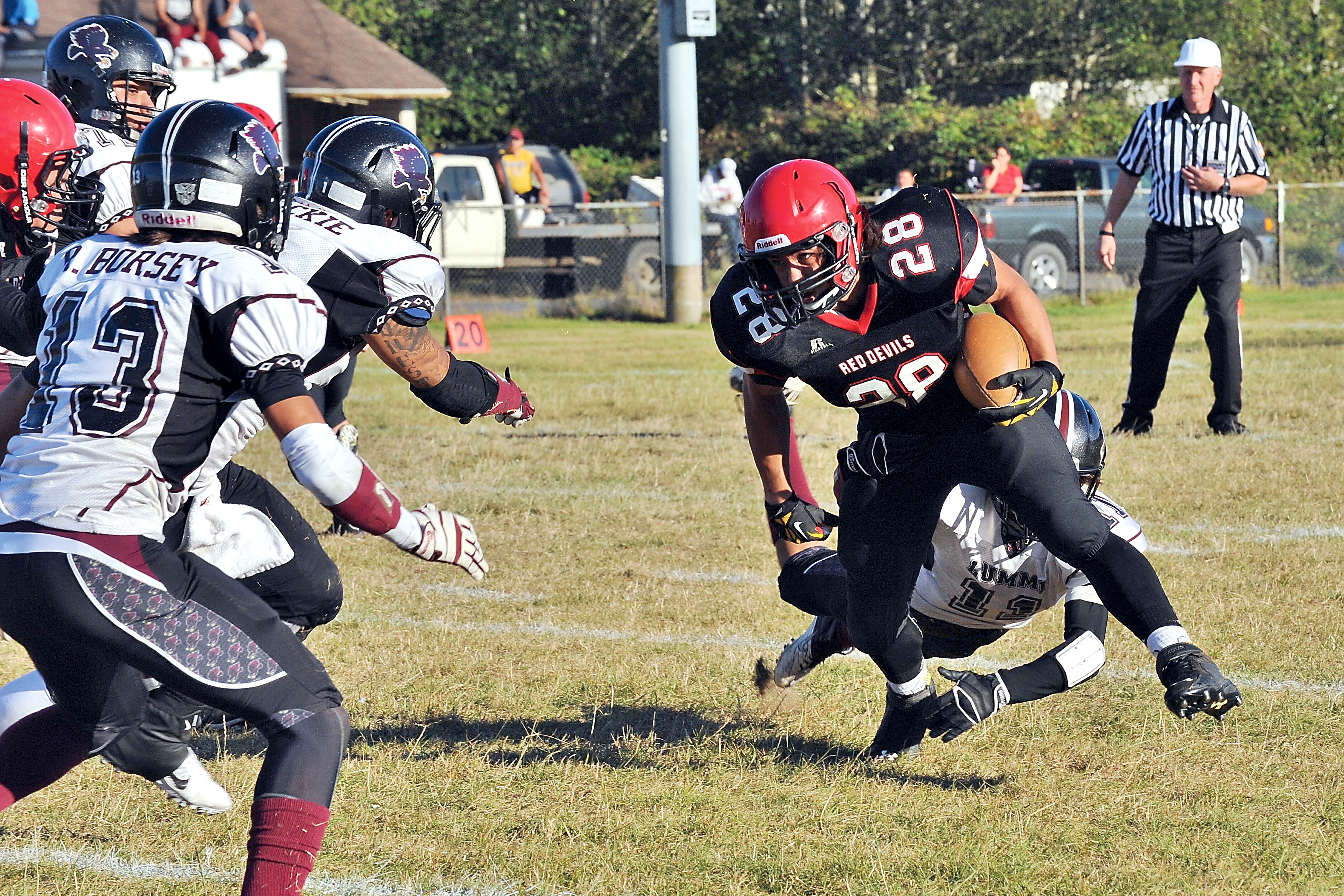 Neah Bay's Elisha Winck (28) runs past Lummi's Raven Borsey (11) into a wall of defenders