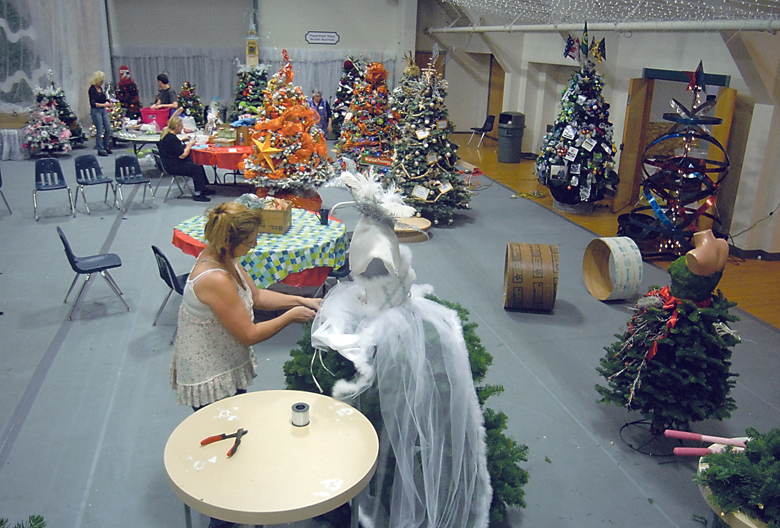 Marilyn Lamb of Port Angeles decorates a tree Wednesday in preparation for this weekend's Festival of Trees at the Vern Burton Community Center in Port Angeles. Keith Thorpe/Peninsula Daily News