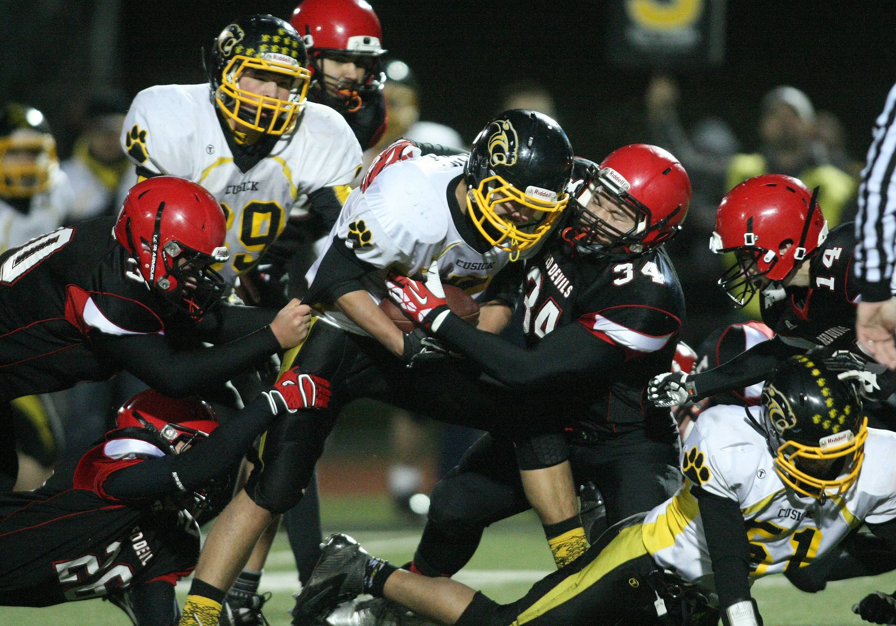 Neah Bay's John Reamer (34) teams with Bill Hanson (30) Ezekiel Greene (26) and Cameron Buzzell (14) to take down Cusick running back Alec Bluff. David Willoughby/for Peninsula Daily News