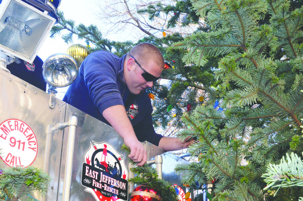 East Jefferson Fire-Rescue's Justin Fletcher uses the ladder truck to decorate the higher reaches of the community Christmas tree Wednesday in Port Townsend. The tree will be lighted in a ceremony at 4:30 p.m. Saturday. Charlie Bermant/Peninsula Daily News